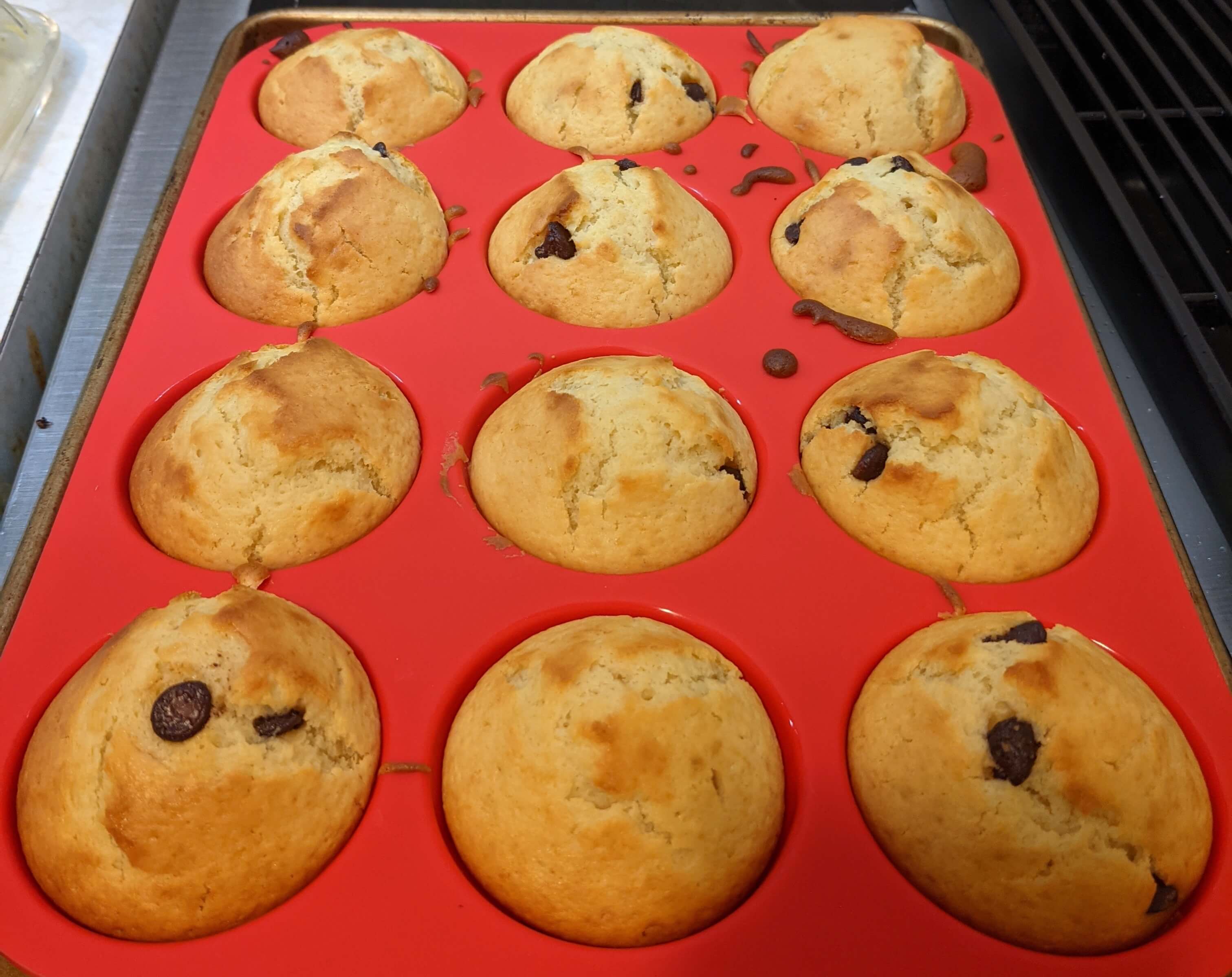 Chocolate chip muffins in a red silicon muffin pan